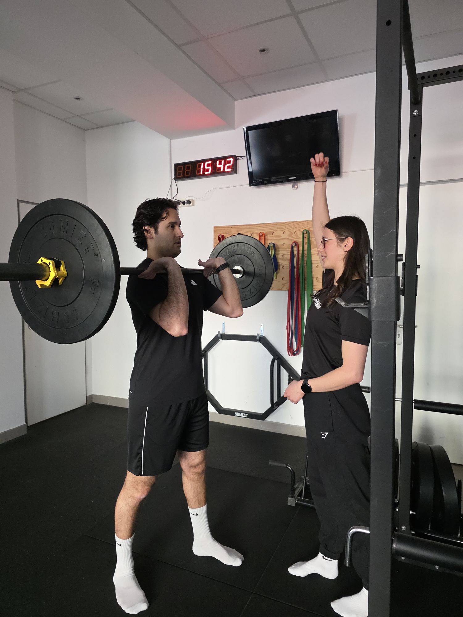 Personal Trainerin Paula coacht einen Kunden beim Langhanteltraining im STRONGFIT Gym in München-Pasing