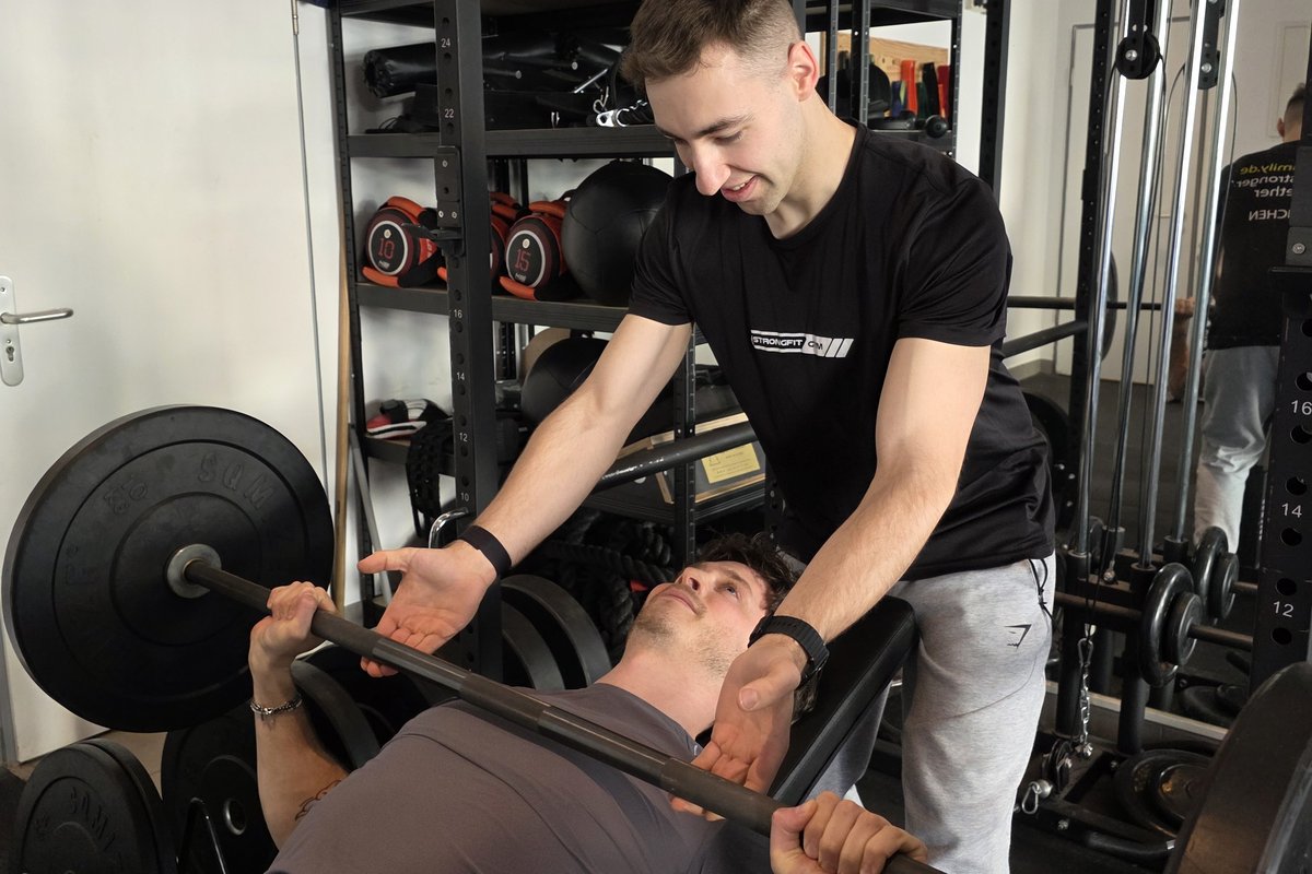 Personal Trainer assisting client with Bench Press